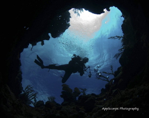 Andrew with camera looking back down this coral chimney. by Richard Apple 